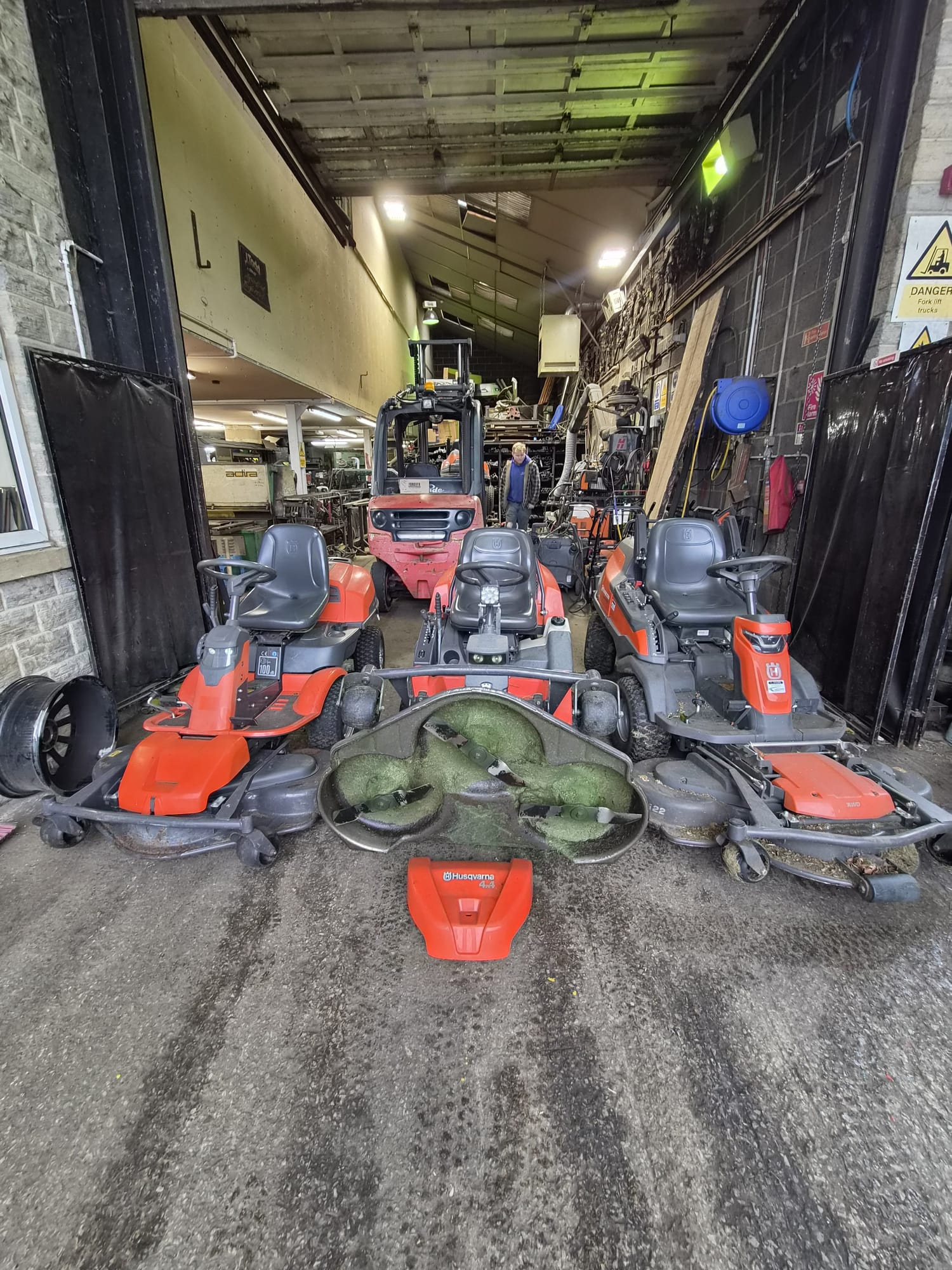 Husqvarna ride-on lawnmowers lined up for servicing